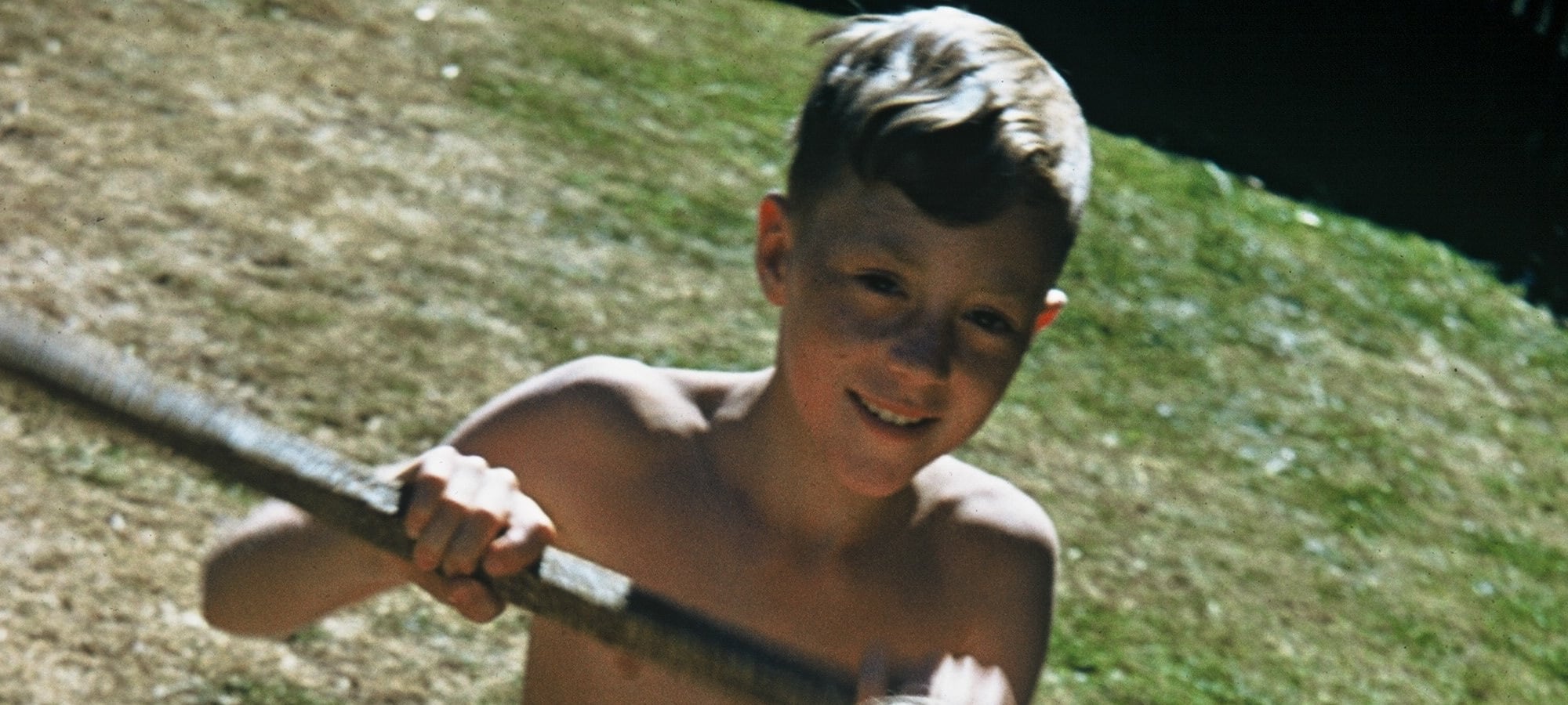 boy in summer pretending to paddle canoe