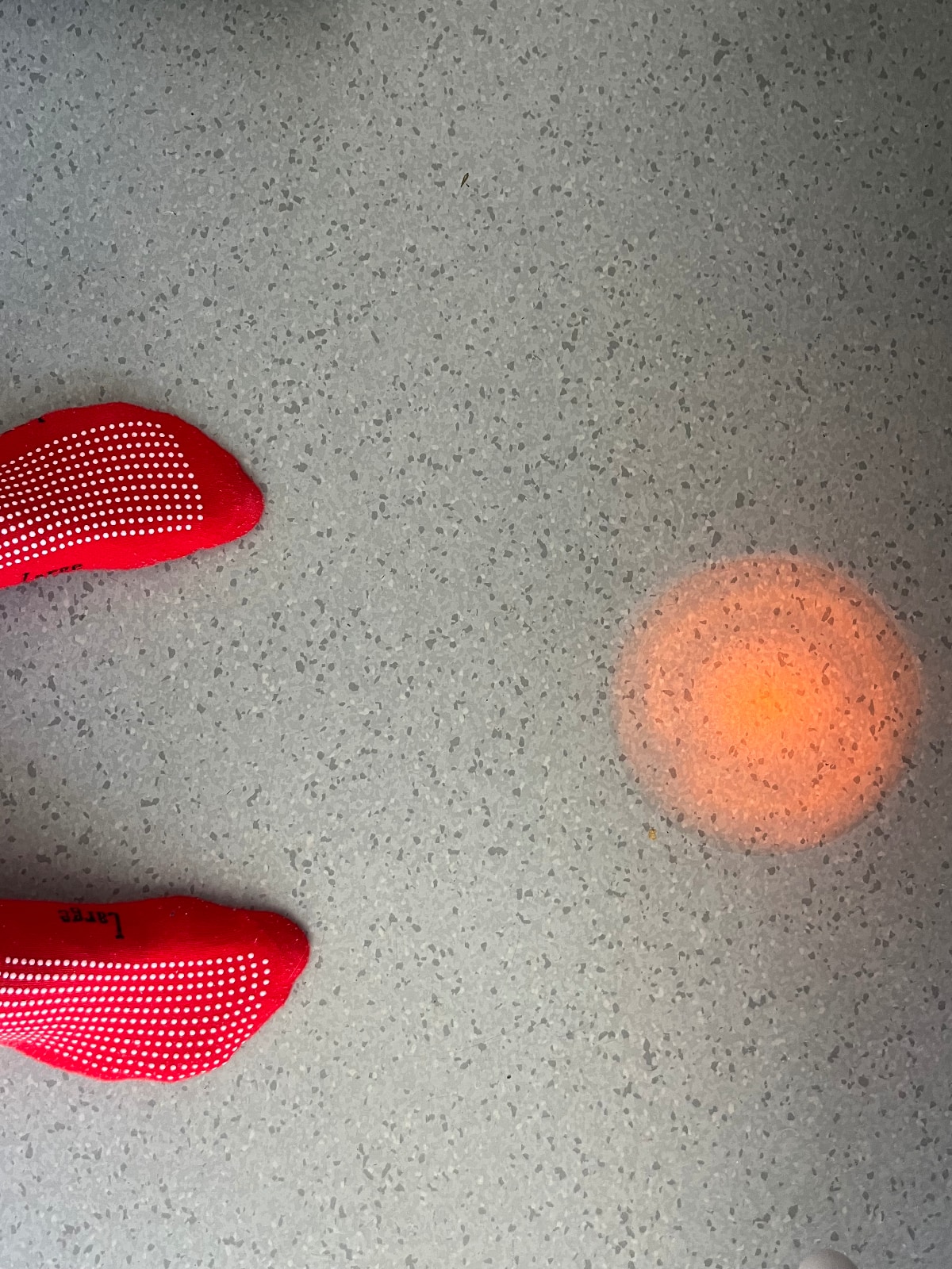 red feet in red hospital socks point to orange glow on floor